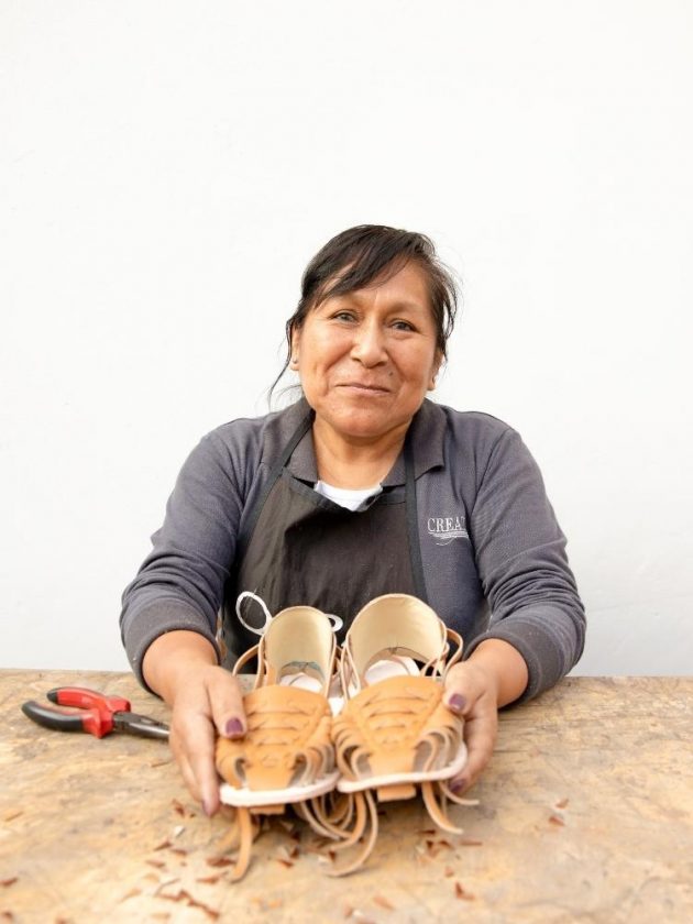 Nisolo's worker holding shoes