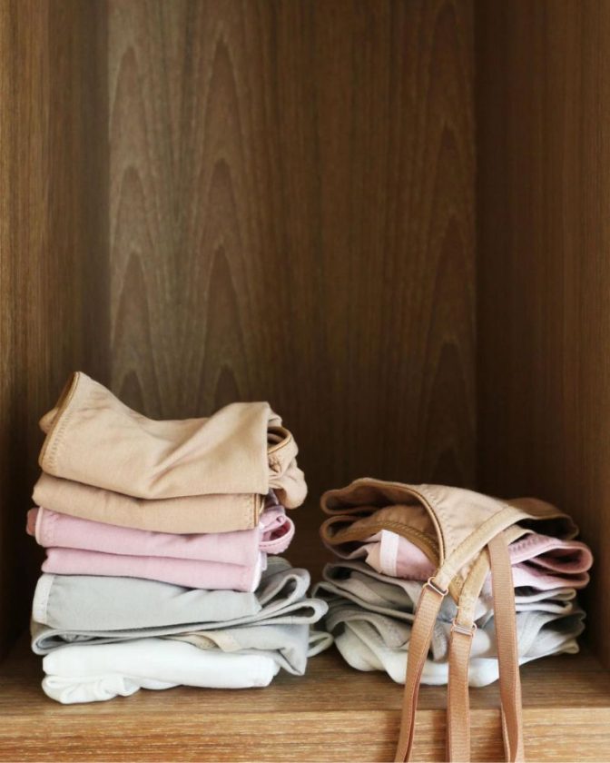 stack of pastel and neutral colored organic underwear and organic bras 