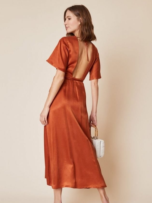 model wearing backless orange silk sustainable dress