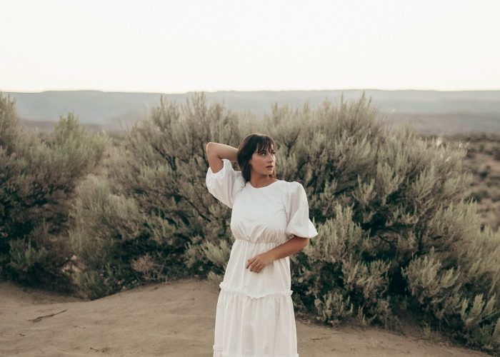 Woman in white dress in field - sustainable living blogs cover image