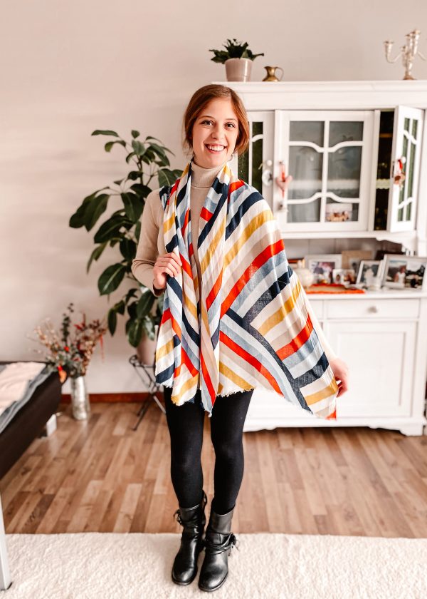 Girl wearing tan turtleneck, black leggings and colorful scarf