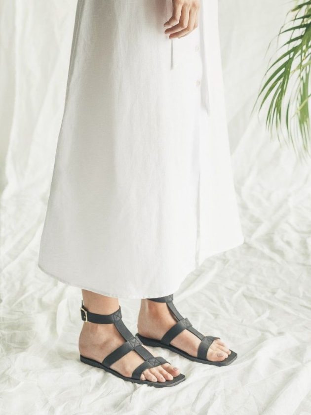 model wearing black vegan sustainable sandals