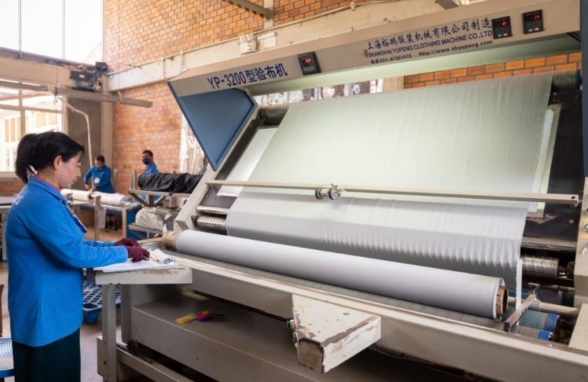 Woman with fabric machine at Pactics