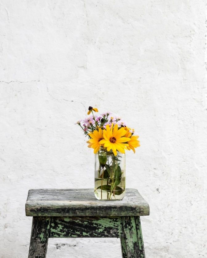 Minimalist image of a stool and flowers