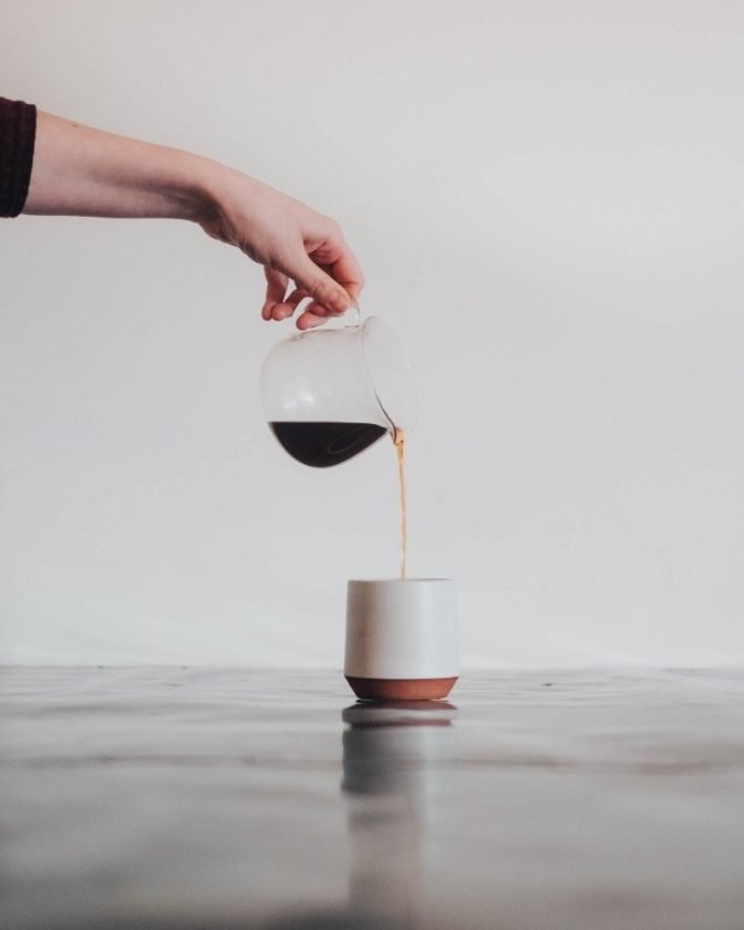 Woman pouring coffee into a mug